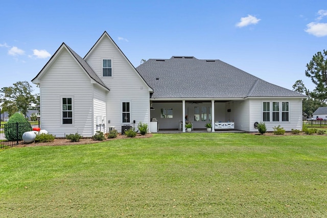 back of property featuring roof with shingles, fence, a yard, and ceiling fan