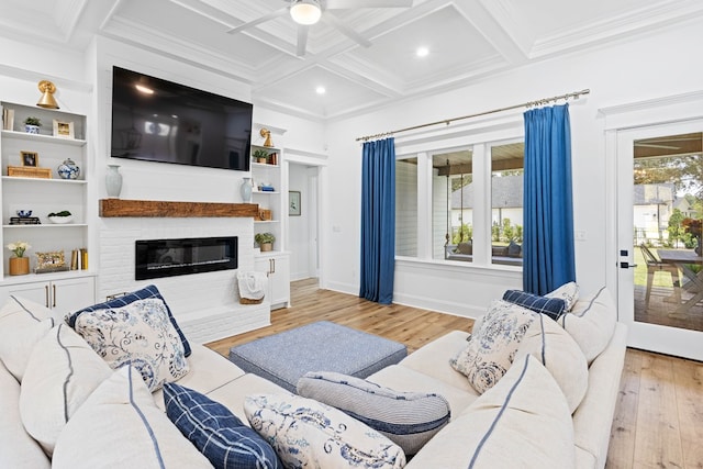 living area with hardwood / wood-style flooring, ceiling fan, a large fireplace, beamed ceiling, and coffered ceiling