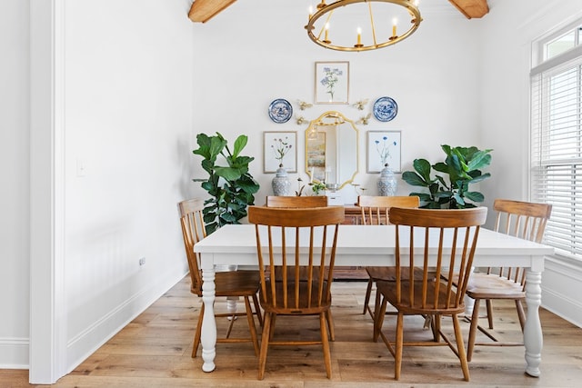 dining space featuring a chandelier, wood finished floors, and baseboards