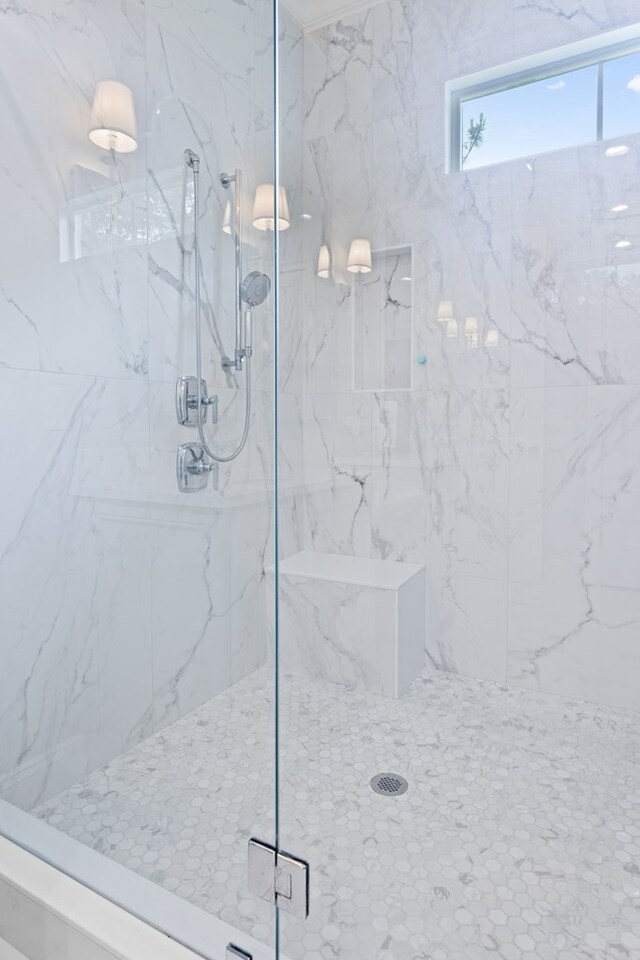 bathroom featuring a marble finish shower