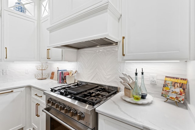 kitchen with white cabinets, high end stainless steel range oven, and custom range hood