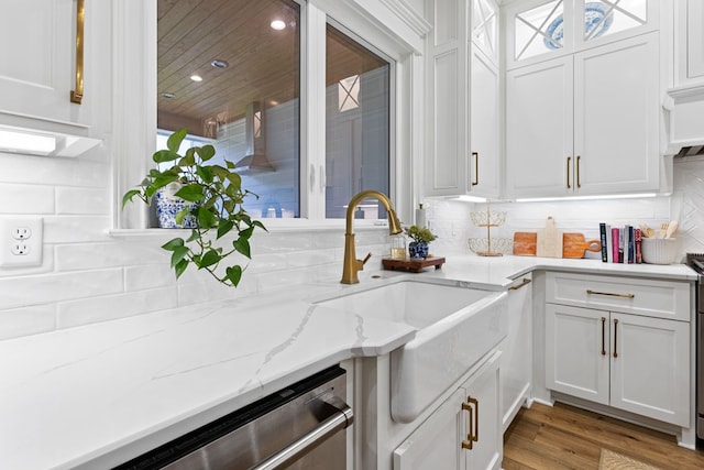 kitchen with white cabinets, backsplash, and a sink