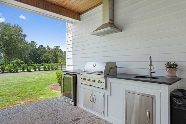 view of patio / terrace with fence, exterior kitchen, a sink, and a grill