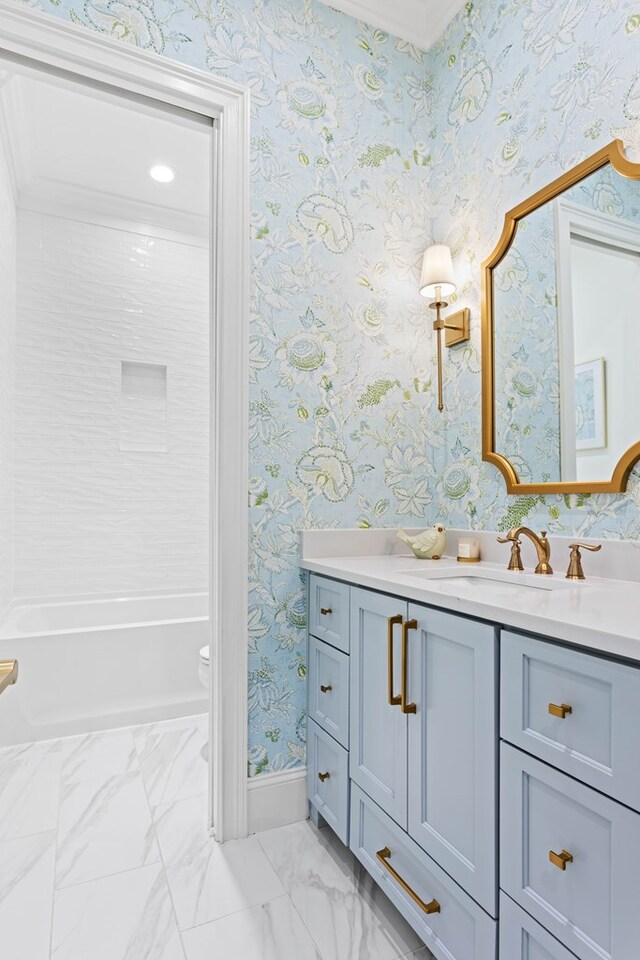 bathroom featuring wallpapered walls, marble finish floor, vanity, baseboards, and shower / tub combination
