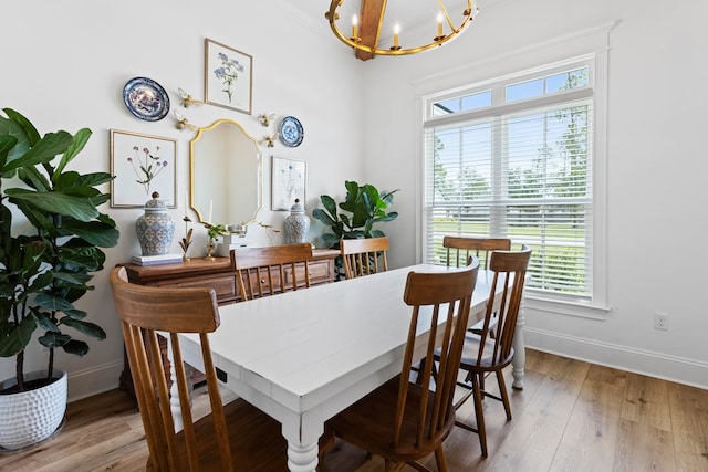 dining room featuring baseboards, wood finished floors, and a chandelier
