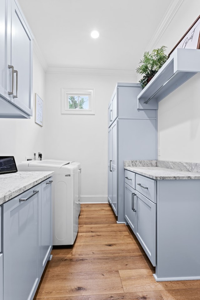 washroom featuring washing machine and clothes dryer, crown molding, cabinet space, light wood finished floors, and recessed lighting