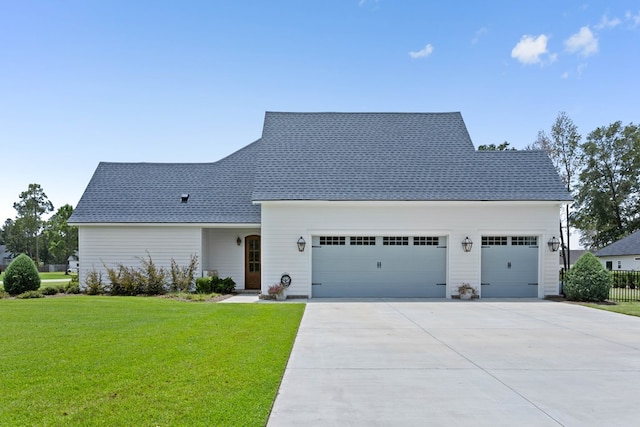 view of front facade featuring an attached garage, a front lawn, fence, and driveway