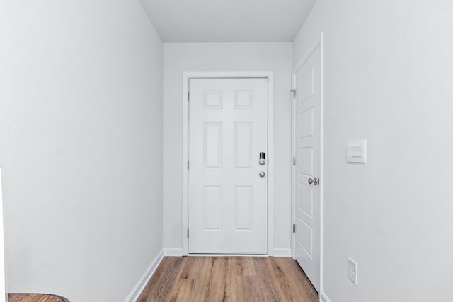 doorway featuring wood finished floors and baseboards