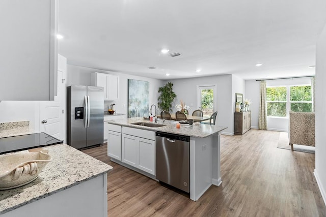 kitchen featuring appliances with stainless steel finishes, visible vents, a sink, and white cabinetry