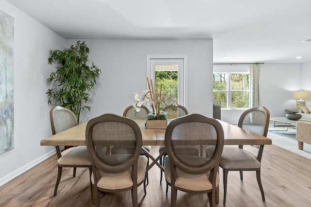 dining area featuring light wood-style flooring and baseboards