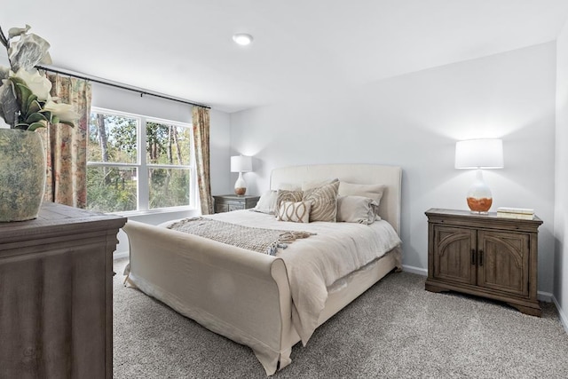 bedroom featuring light carpet and baseboards