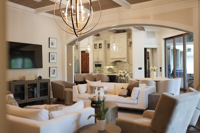 living room featuring beamed ceiling, crown molding, and an inviting chandelier