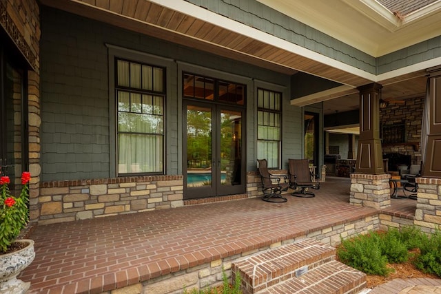 view of exterior entry featuring a porch and french doors