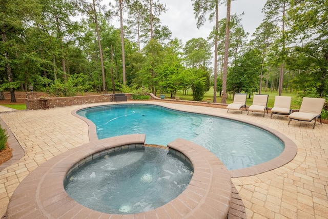 view of pool with a patio area and an in ground hot tub