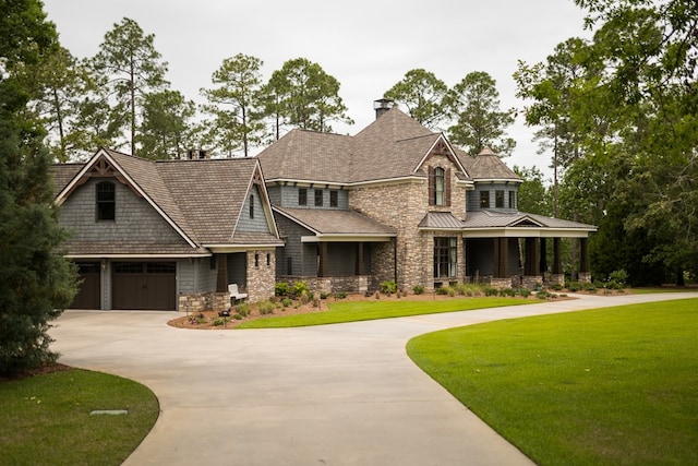 view of front of house with a front lawn, covered porch, and a garage