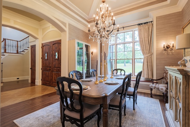 dining room featuring dark hardwood / wood-style flooring, a notable chandelier, and ornamental molding