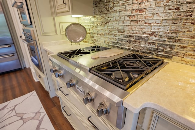 kitchen with backsplash, dark hardwood / wood-style flooring, and appliances with stainless steel finishes