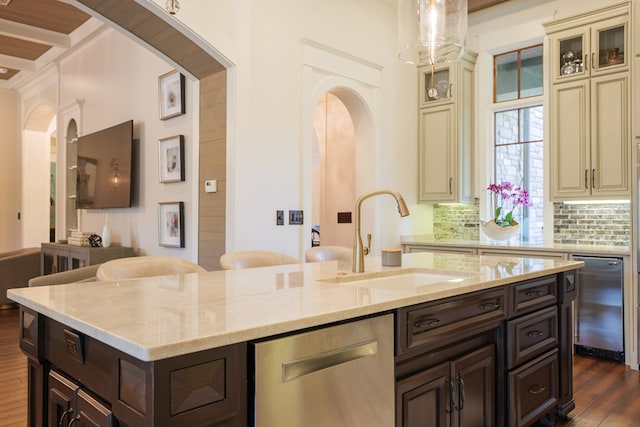 kitchen with dishwasher, cream cabinets, sink, decorative backsplash, and dark hardwood / wood-style flooring