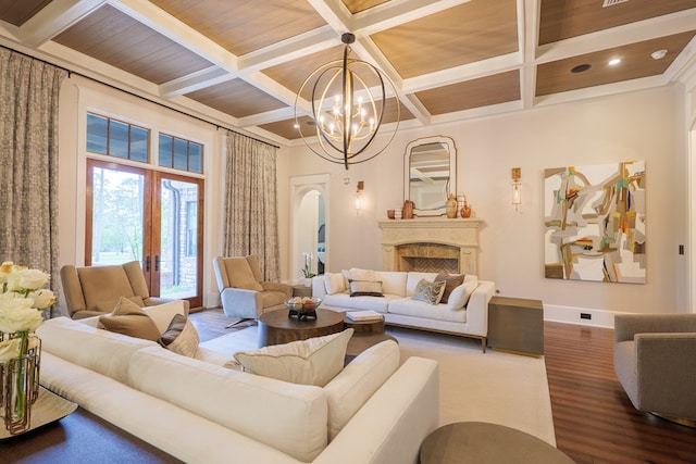 living room featuring coffered ceiling, ornamental molding, beamed ceiling, a notable chandelier, and wood-type flooring