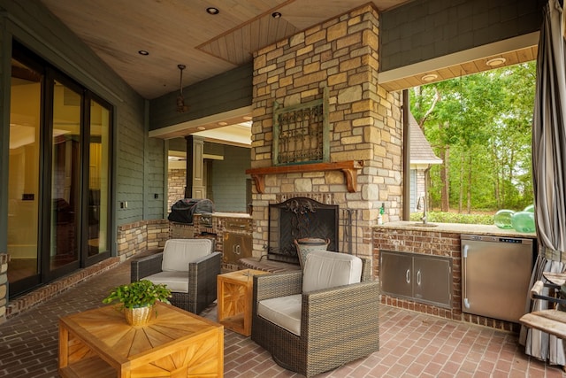 view of patio featuring an outdoor stone fireplace and sink