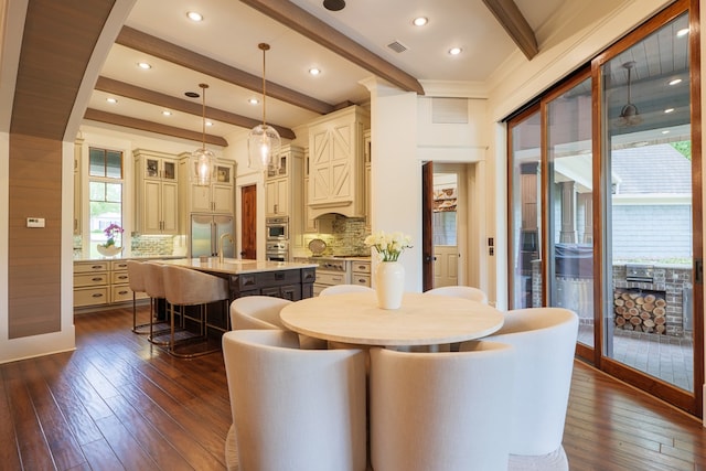 dining space with beamed ceiling and dark hardwood / wood-style floors