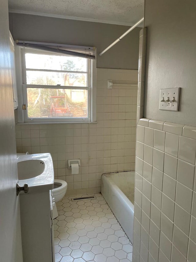 bathroom featuring vanity, tile patterned flooring, toilet, a textured ceiling, and tile walls