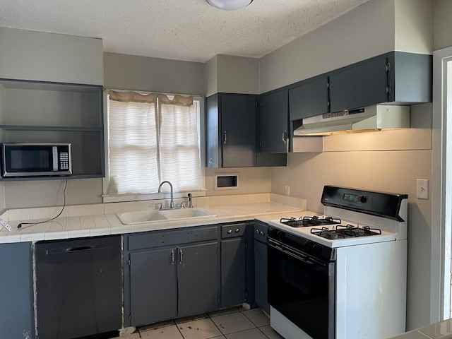 kitchen featuring tile countertops, dishwasher, sink, white gas range oven, and a textured ceiling