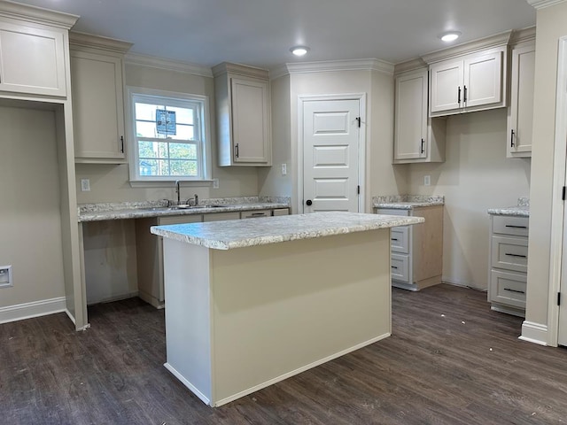 kitchen with dark hardwood / wood-style flooring, a center island, ornamental molding, and sink