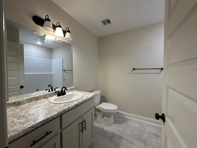 bathroom featuring a shower, vanity, and toilet