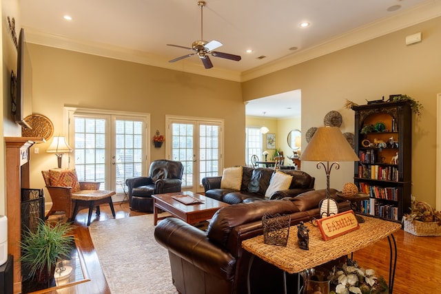 living room with french doors, ornamental molding, wood-type flooring, and ceiling fan