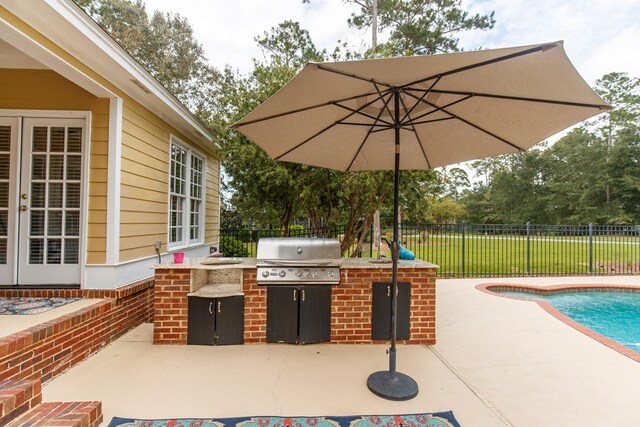 view of patio with a fenced backyard, grilling area, a fenced in pool, and area for grilling