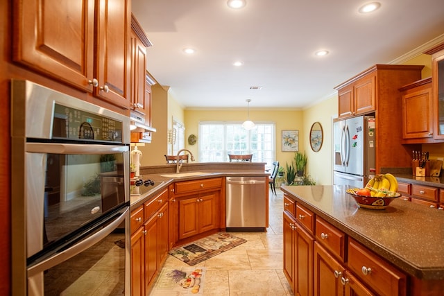kitchen with a sink, crown molding, appliances with stainless steel finishes, and a peninsula