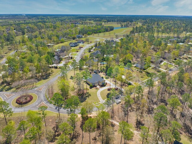 birds eye view of property featuring a view of trees