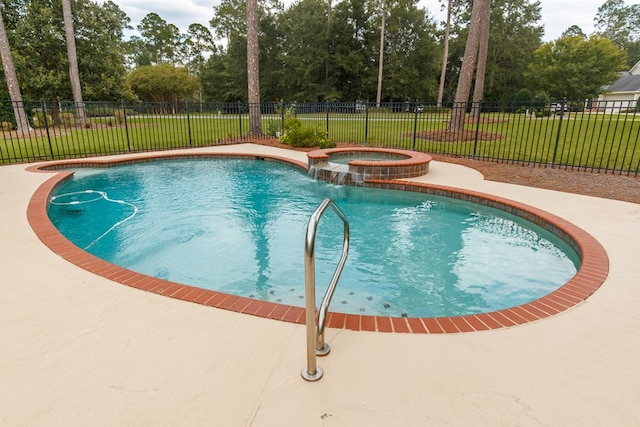 view of swimming pool featuring a pool with connected hot tub, fence, and a yard