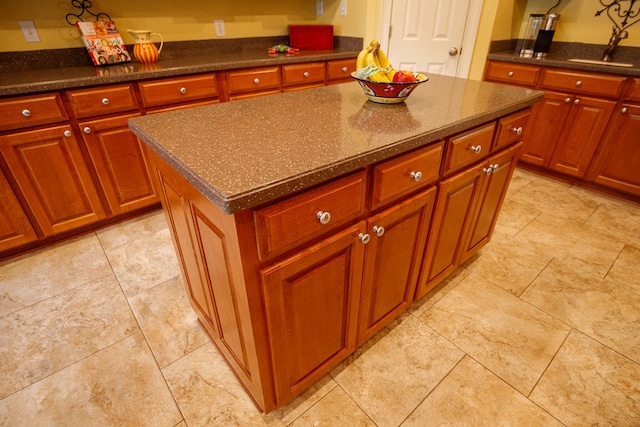 kitchen with light tile patterned floors, a sink, and a kitchen island