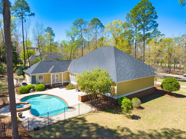 view of pool featuring a pool with connected hot tub, french doors, fence, a patio, and a lawn
