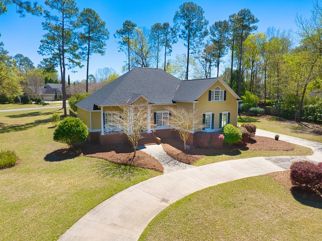 view of front facade featuring a front lawn, french doors, and curved driveway