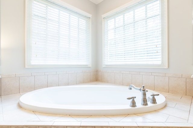 bathroom featuring a healthy amount of sunlight and tiled bath