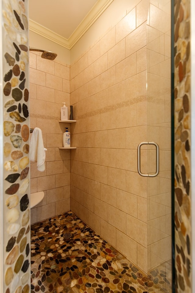 bathroom with stone finish floor, crown molding, and a shower stall
