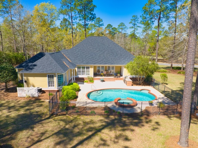 view of pool featuring a patio area, a lawn, a pool with connected hot tub, and fence