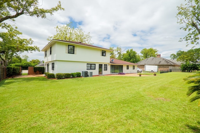 rear view of house featuring a lawn, central air condition unit, and a patio