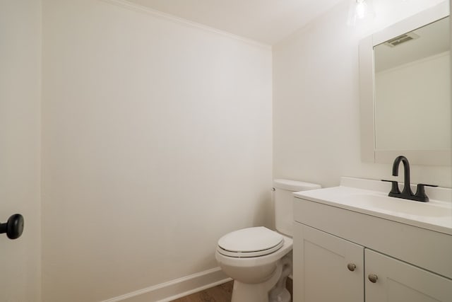 bathroom featuring hardwood / wood-style floors, vanity, ornamental molding, and toilet