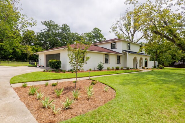 mediterranean / spanish-style house with a garage and a front yard