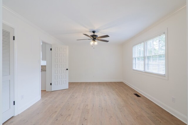 spare room featuring ceiling fan, ornamental molding, and light wood-type flooring