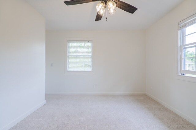 empty room featuring ceiling fan and light colored carpet