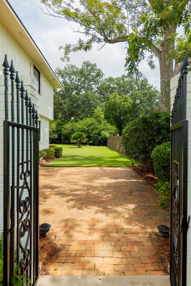 view of gate featuring a yard and a patio area