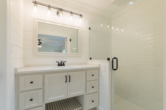 bathroom featuring ceiling fan, crown molding, vanity, and walk in shower