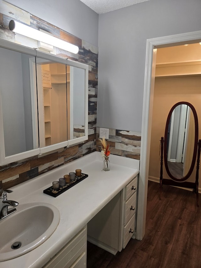 bathroom with hardwood / wood-style floors, vanity, and a textured ceiling