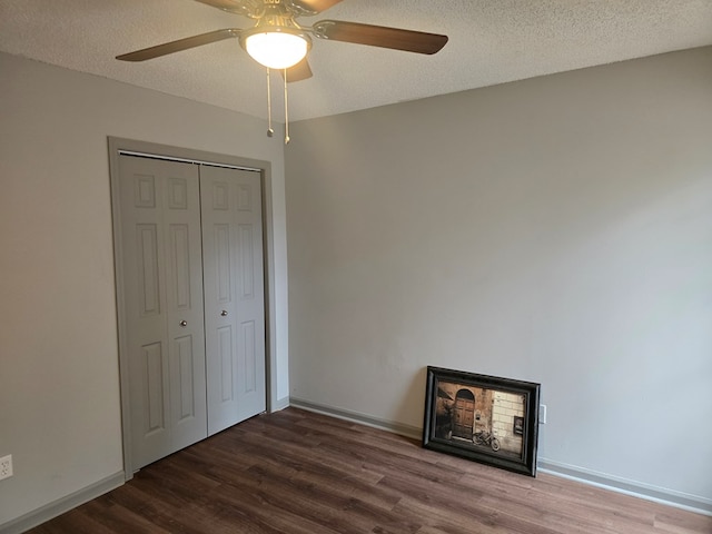 unfurnished bedroom with hardwood / wood-style floors, a textured ceiling, a closet, and ceiling fan