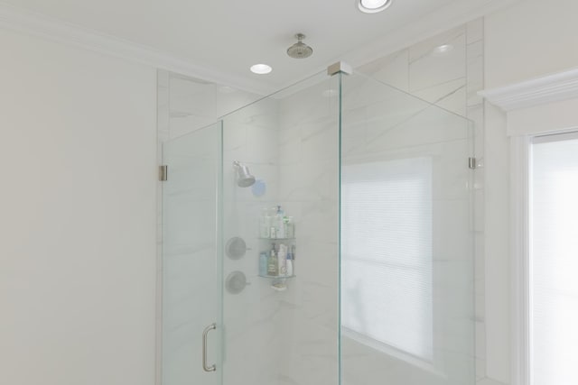 bathroom with a marble finish shower and ornamental molding